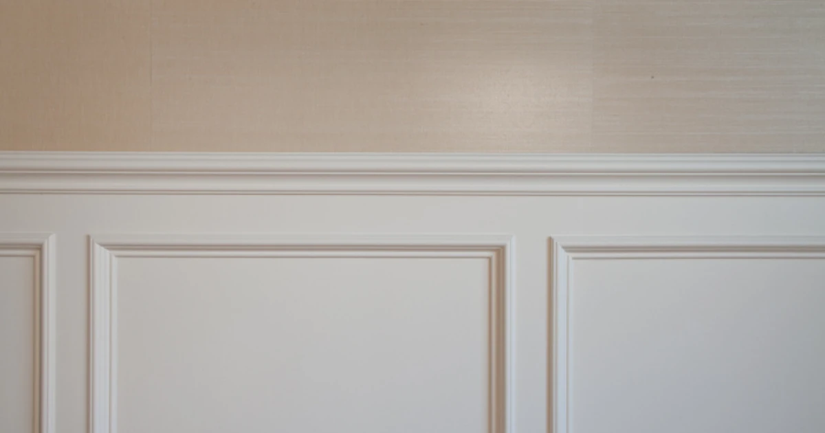 Crisp white painted wainscoting and chair rail against a soft beige upper wall.