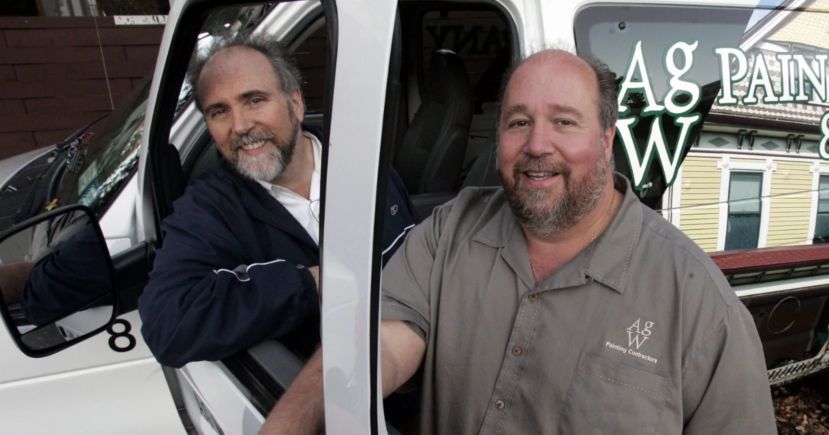Two A.G. Williams Painting Company owners with a company painting van outside a home in New York.