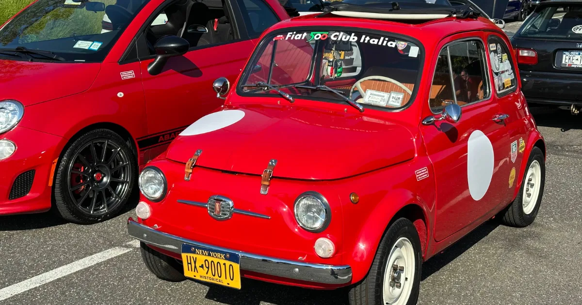 Red vintage Fiat 500 with white racing roundels at Cars & Coffee.