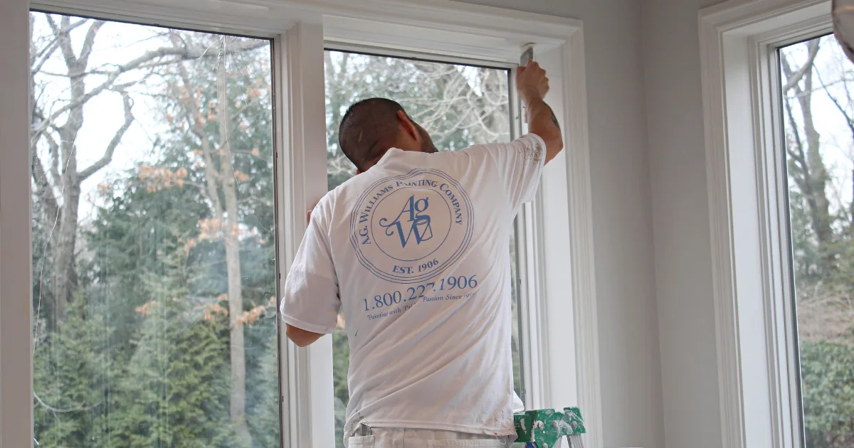 A.G. Williams painter applying paint to interior window trim.