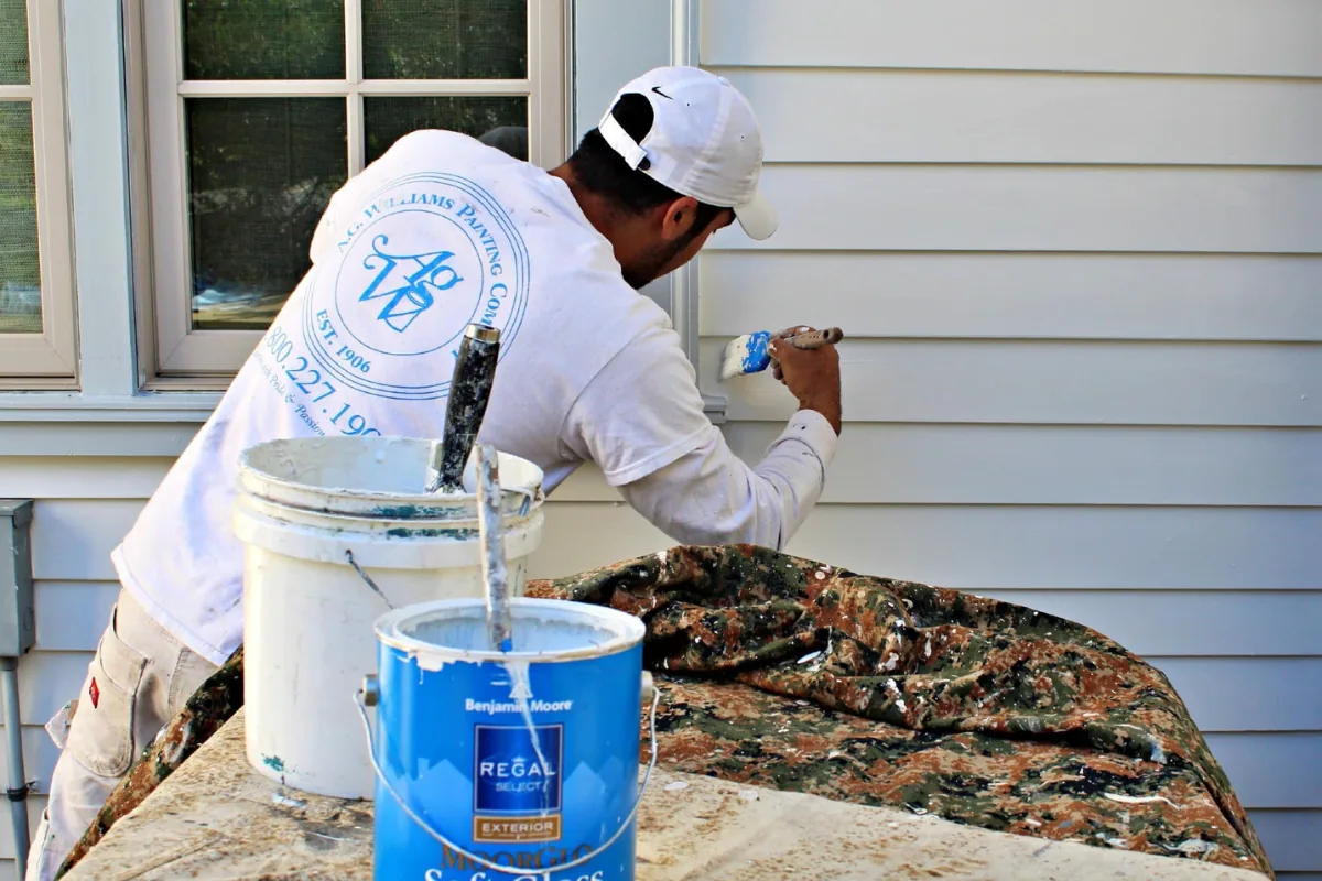 A.G. Williams painter brushing a finish coat onto exterior siding.