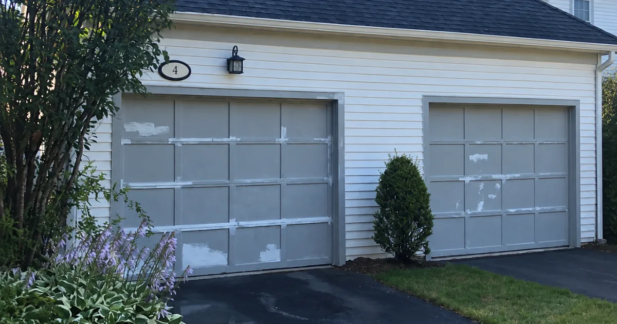 Gray garage doors scraped, spot-patched, and ready for primer.