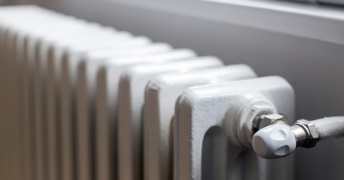 Close view of a white cast-iron radiator and its valve.