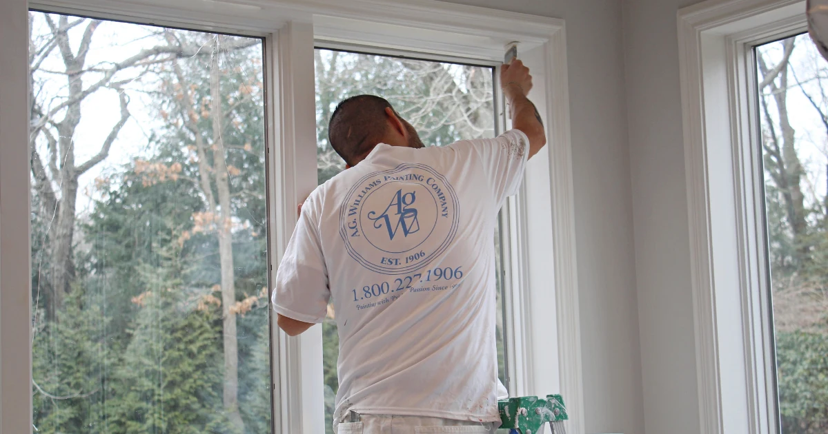 A.G. Williams painter applying a precise finish to interior window trim.